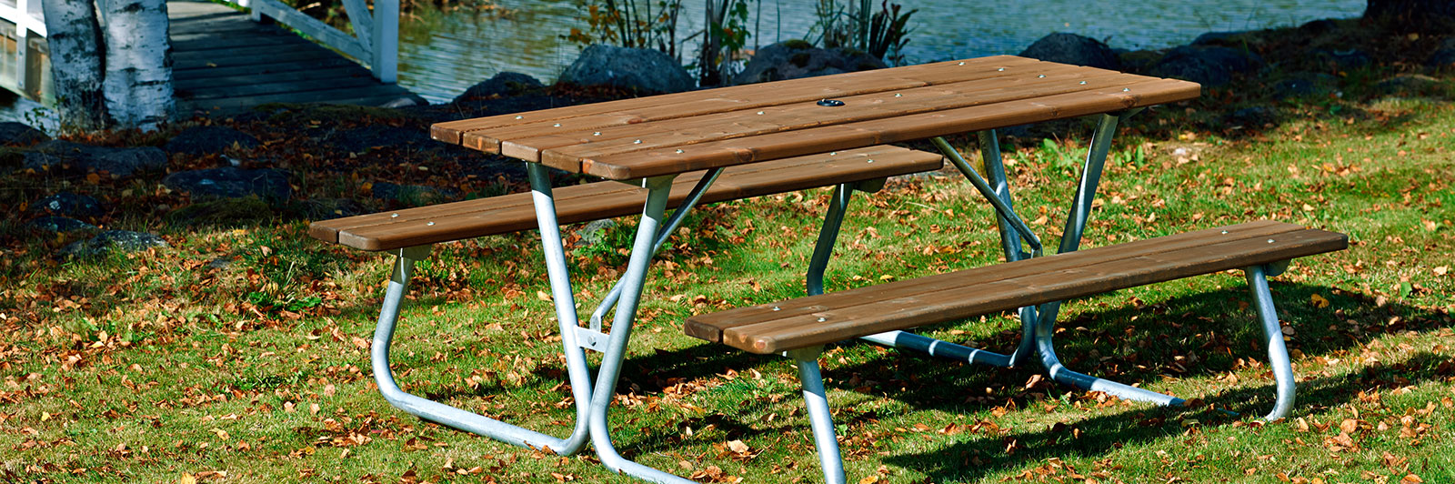 Wooden picnic table with benches at a park.